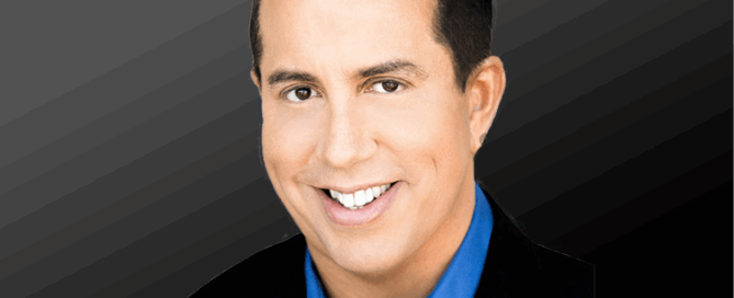 headshot of Paul Scott Adamo wearing a blue shirt with a black jacket against a dark background